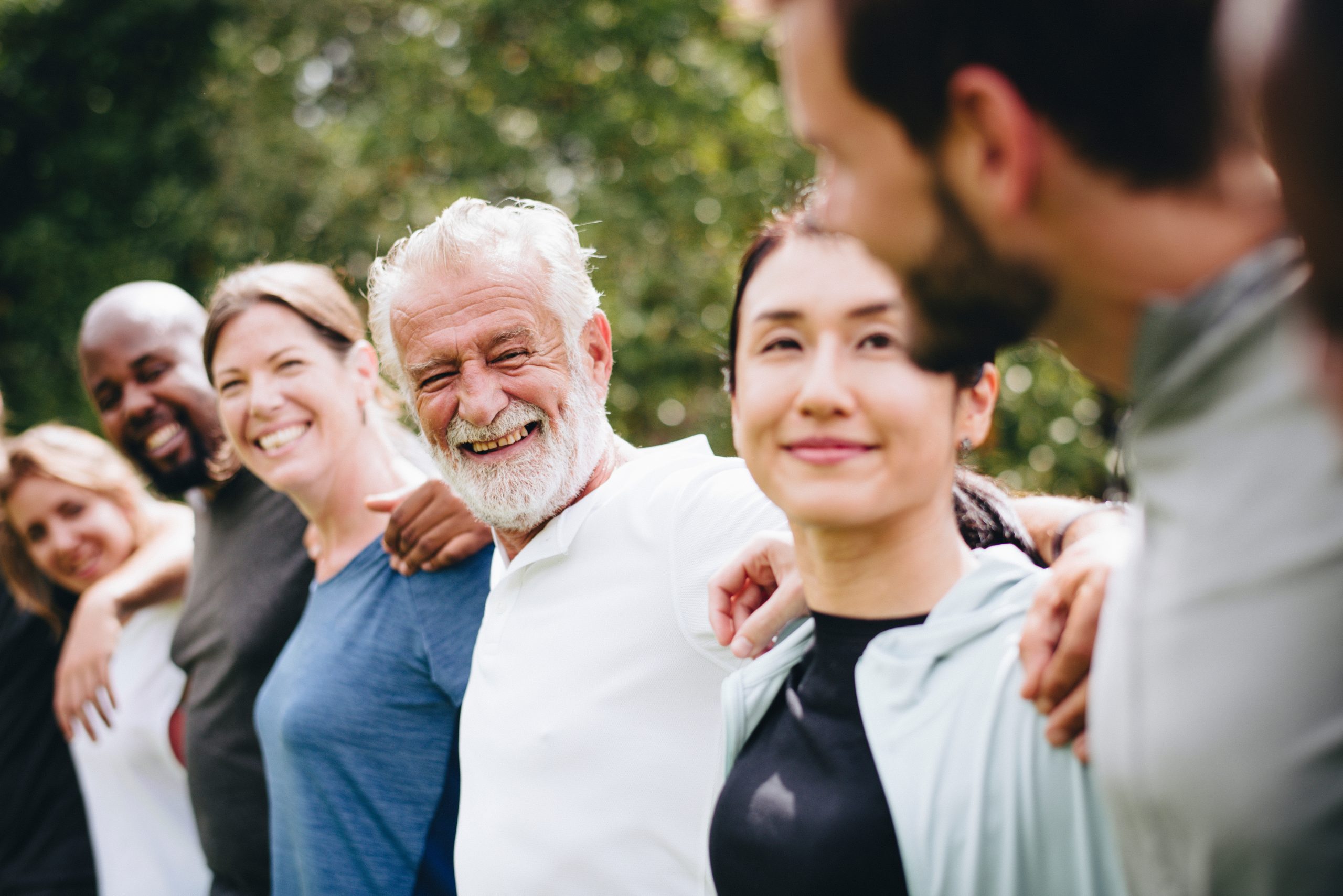 Menschen verschiedener Generationen stehen gemeinsam im Grünen